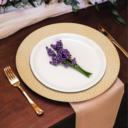 Gold charger plates styled with glassware and cutlery on a dining table