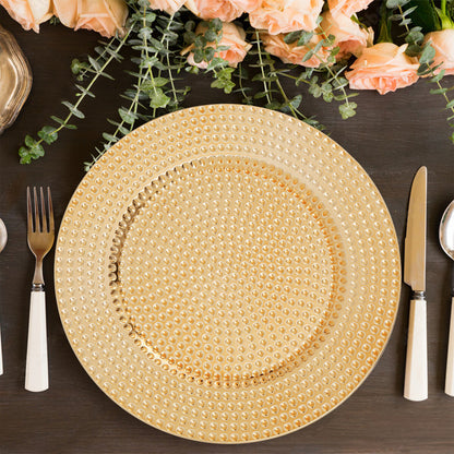 Four gold hammered charger plates styled across a dining table