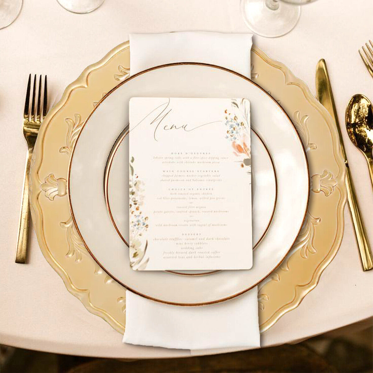 Four gold baroque charger plates styled across a dining table
