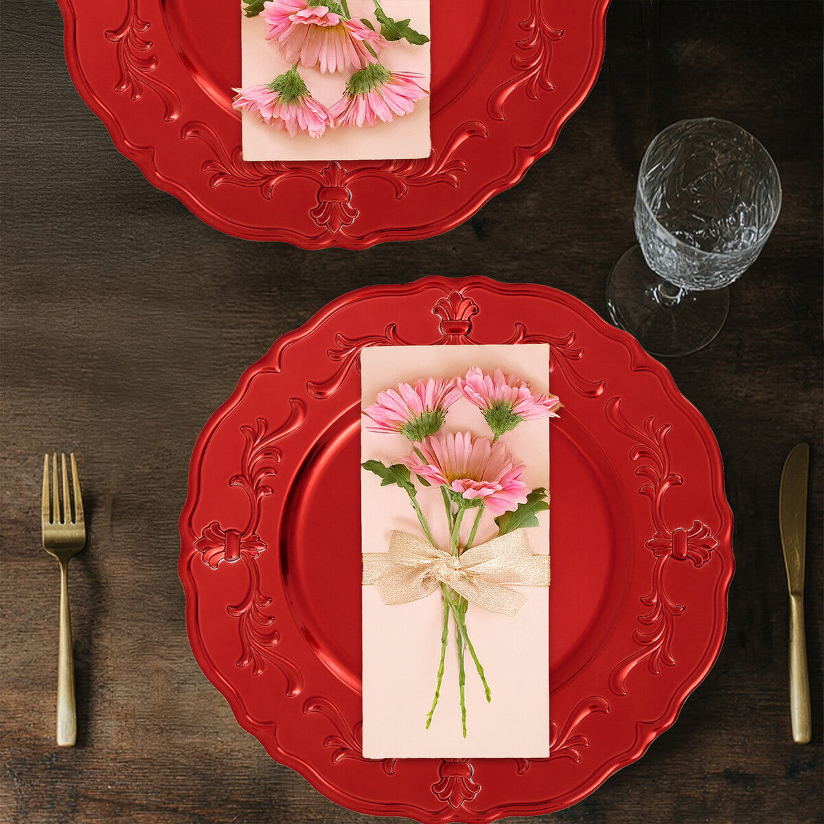 Four red baroque charger plates styled across a dining table