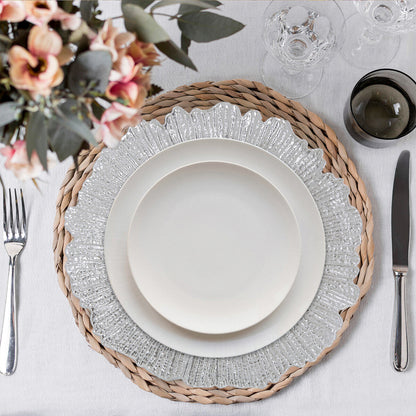 Four silver reef charger plates styled across a dining table