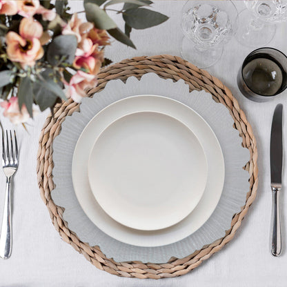Four white reef charger plates styled across a dining table