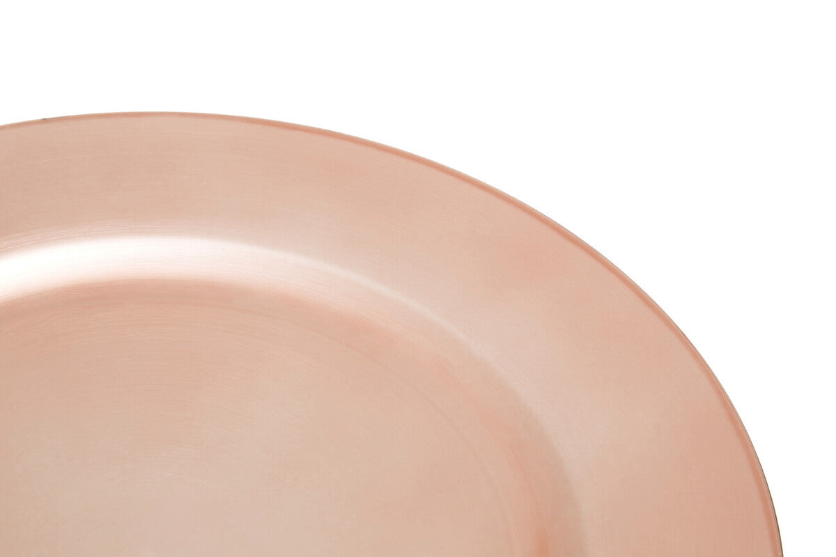 Rose gold charger plate laid beneath a dinner plate in a table setting