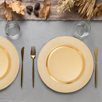 Four gold charger plates styled across a dining table