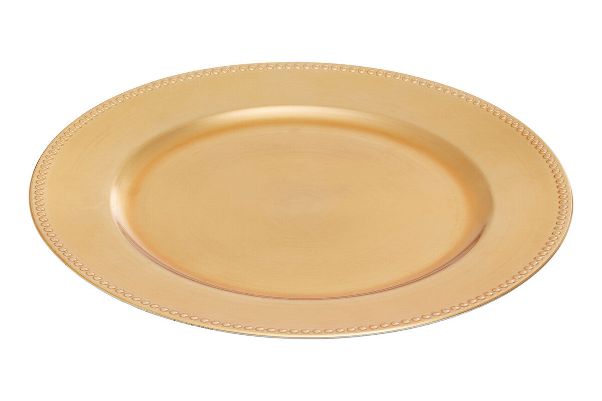 Gold charger plate laid beneath a dinner plate in a place setting