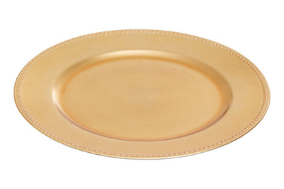 Gold charger plate laid beneath a dinner plate in a place setting