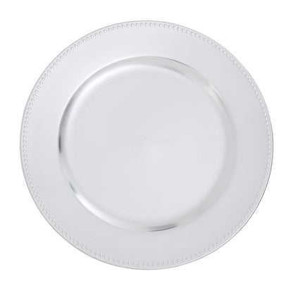 Silver charger plate laid beneath a dinner plate in a place setting