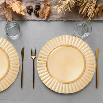 Four gold wave charger plates styled across a dining table