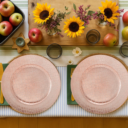 Four rose gold charger plates styled across a dining table