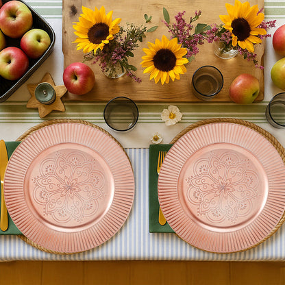 Four rose gold charger plates styled across a dining table