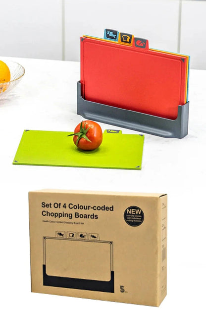 Set of 4 colour-coded chopping boards with a tomato on a green board, next to their packaging.