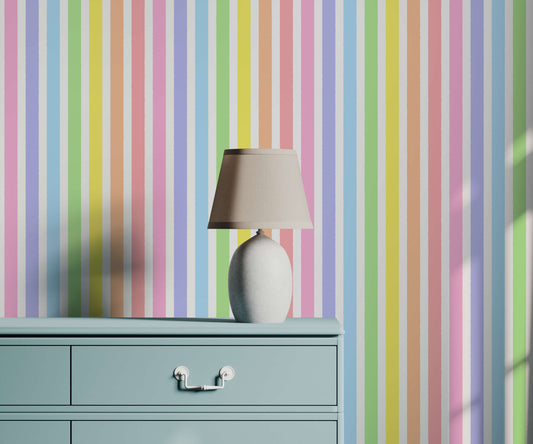 Pastel striped wallpaper with a lamp and vase on a green cabinet.