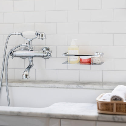 Smedbo Sideline DK3001 Polished Chrome Shower Basket with Solid Tray — Wall-Mounted on White Subway Tiles Above Marble Bath, Styled with Skincare Products