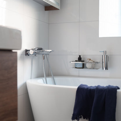 Smedbo Sideline DK3001 Polished Chrome Shower Basket in Modern Bathroom — Wall-Mounted Above Freestanding Bath with Soap Dispenser, Styled with Bath Products and Navy Towel
