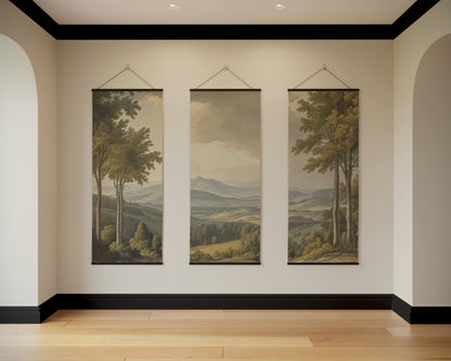 Three landscape paintings hanging on a wall in a room with wooden flooring.