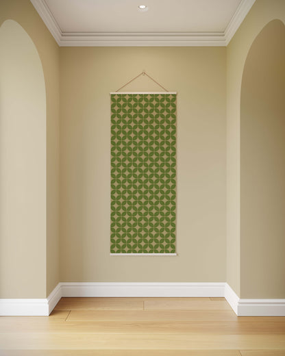Green patterned wall hanging on a beige wall with wooden floor