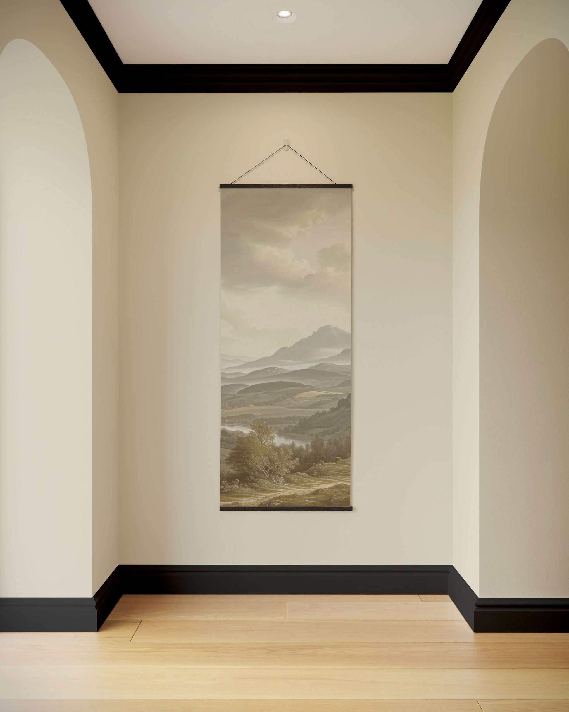 Wall art of a mountain landscape hanging in a room with beige walls and wooden floor.
