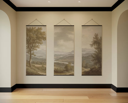 Three landscape paintings hanging on a wall in a room with wooden flooring.