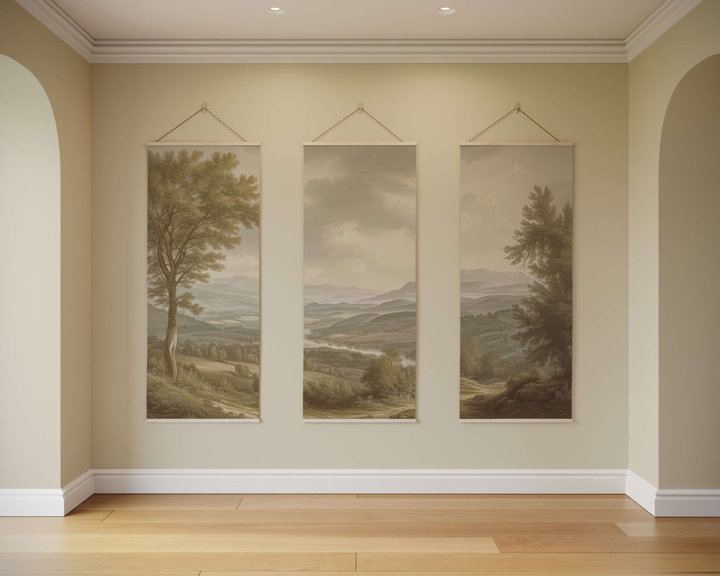 Three landscape paintings hanging on a wall in a room with wooden flooring.