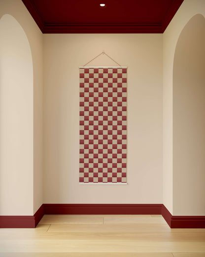 Checkered tapestry hanging on a wall with arched doorways and a red ceiling.