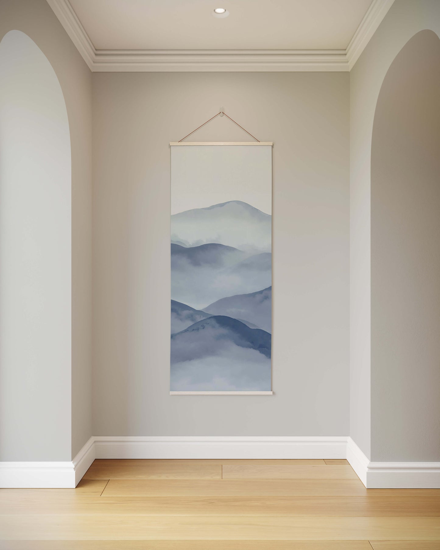 Wall art of mountain landscape hanging in a room with light gray walls and wooden floor.