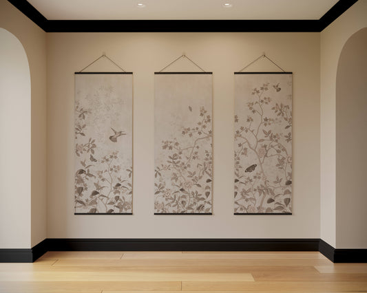 Three floral wall hangings on a beige wall with black trim.