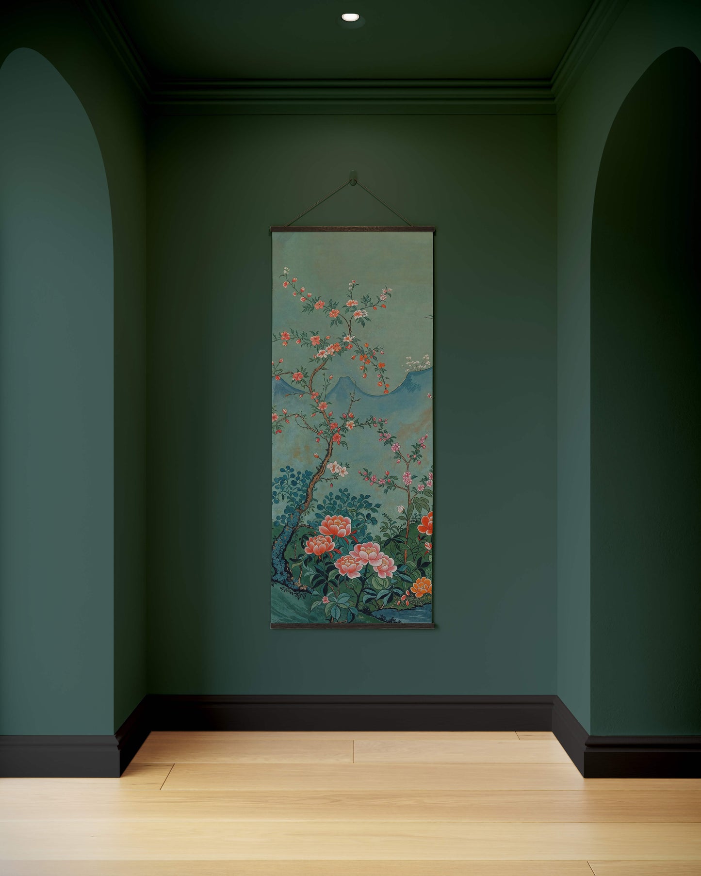 Floral tapestry hanging on a green wall in a room with wooden flooring.