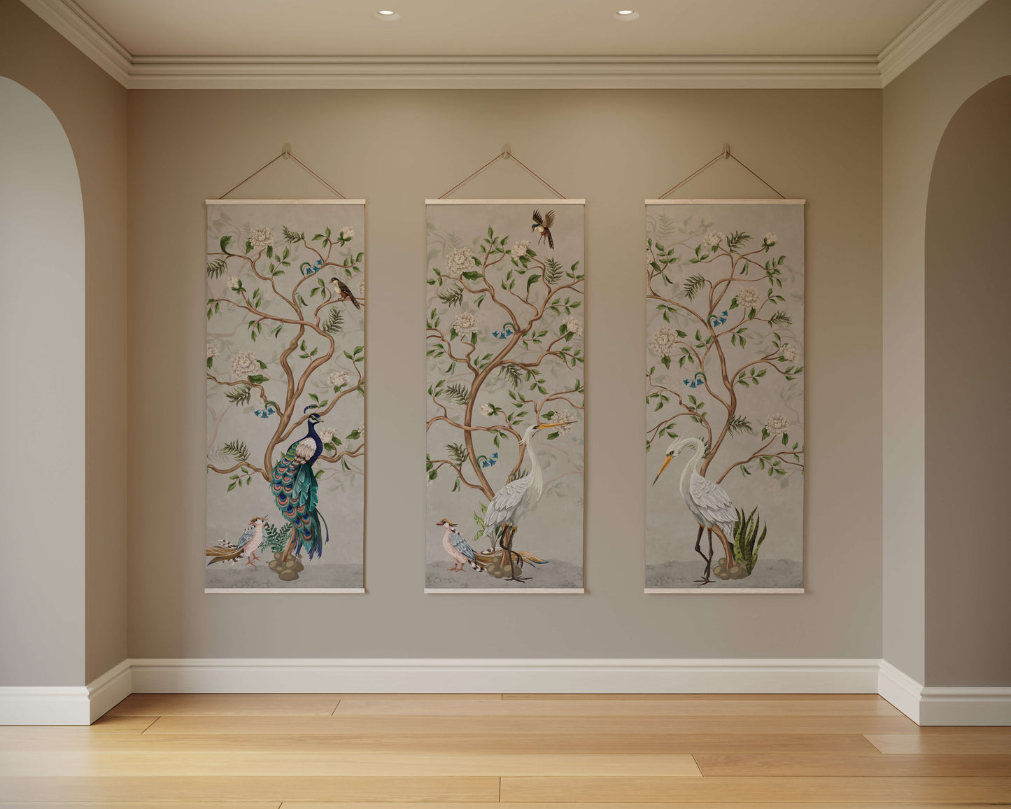 Three wall hangings with nature-themed designs of birds and trees on a beige wall.