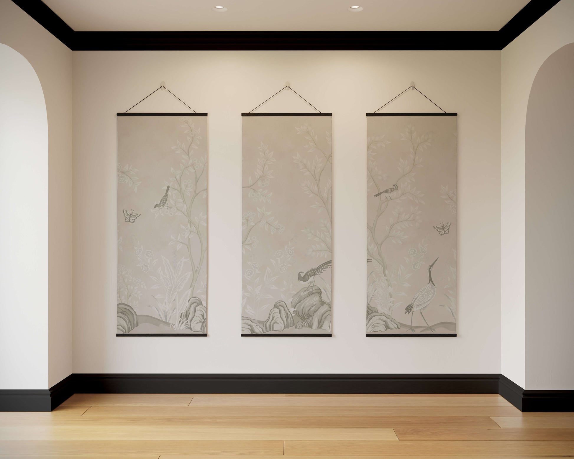 Three hanging scrolls on a wall in a room with wooden flooring and black baseboards.