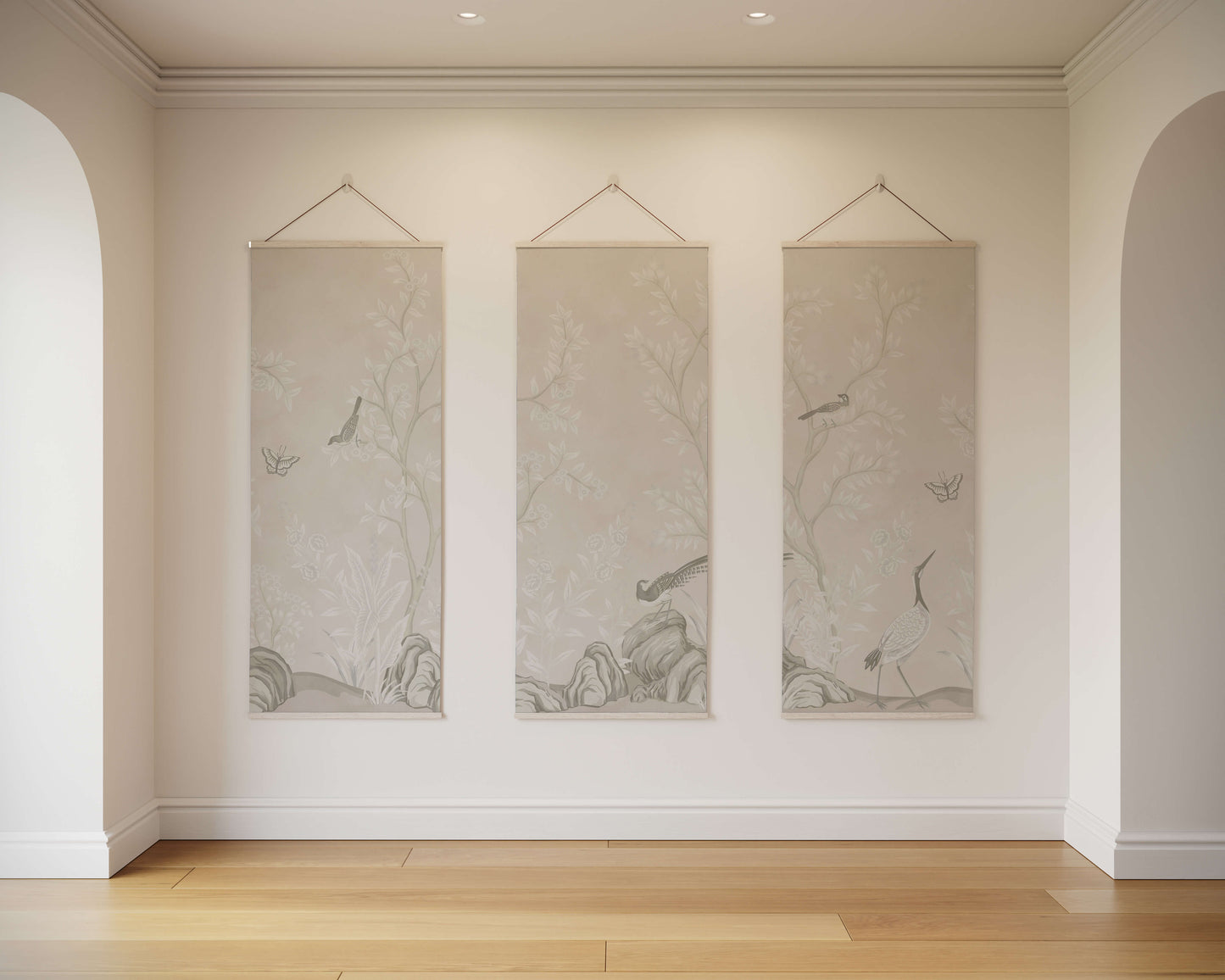 Three hanging wall art pieces on a neutral wall with wooden flooring.
