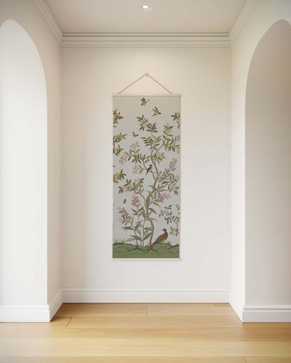 Decorative wall hanging with floral and bird design in a room with white walls and wooden floor.