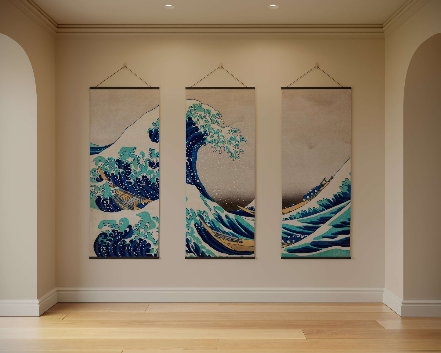 Three hanging wall art pieces depicting waves in a room with beige walls and wooden flooring.