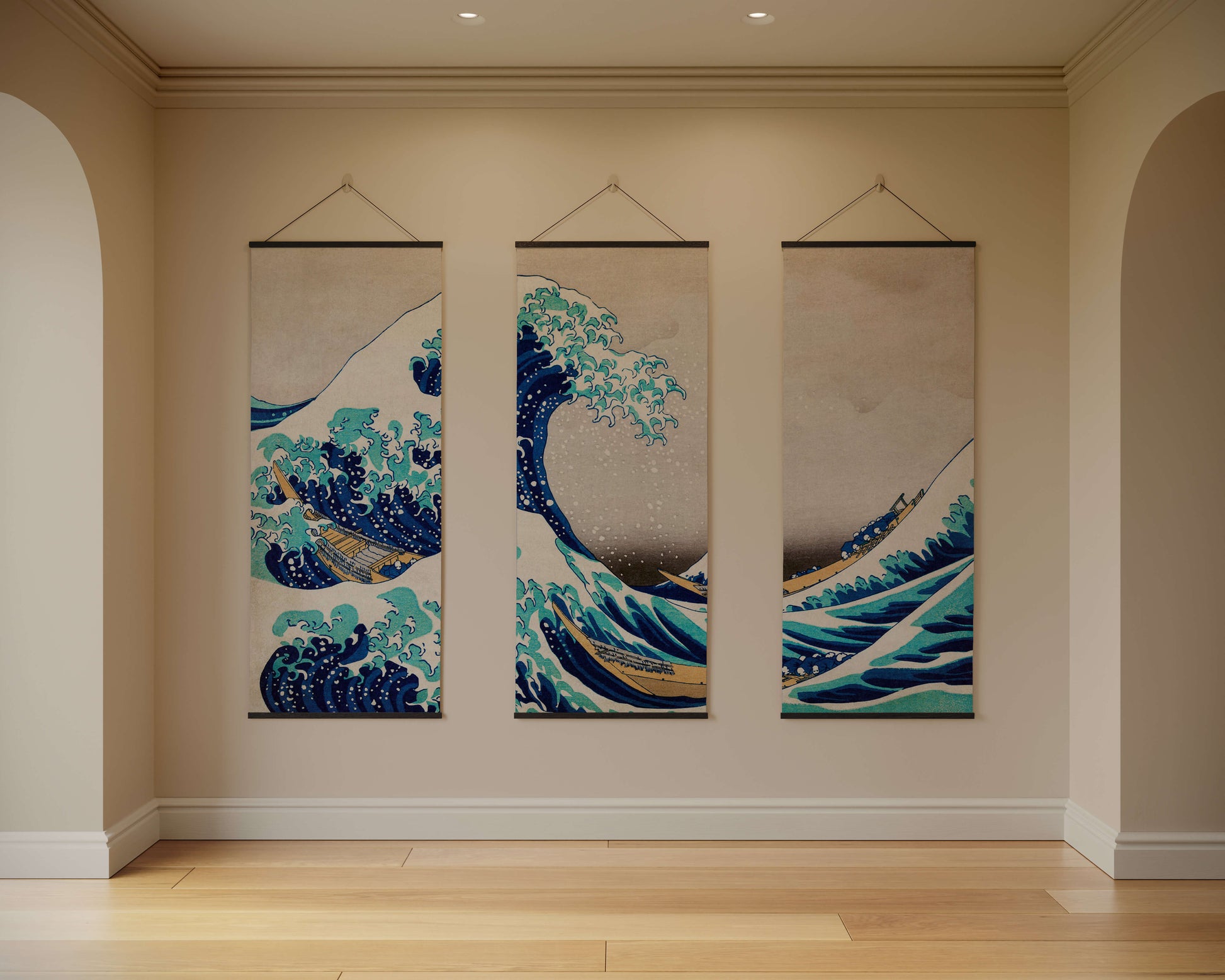 Three hanging wall art pieces depicting waves in a room with beige walls and wooden flooring.