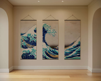 Three hanging wall art pieces depicting waves in a room with beige walls and wooden flooring.