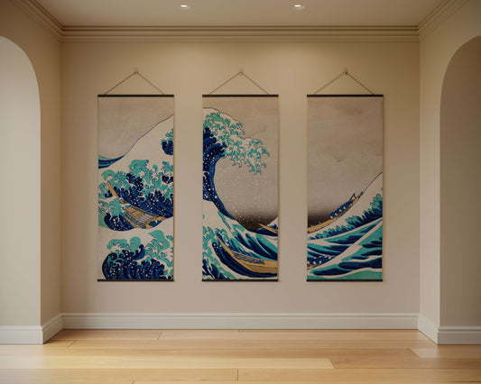 Three hanging wall art pieces depicting waves in a room with beige walls and wooden flooring.