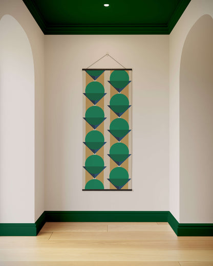 Geometric patterned tapestry hanging on a wall with green accents