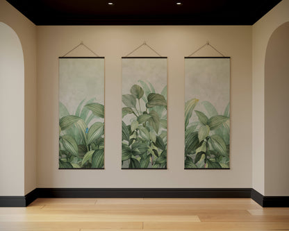 Three vertical wall hangings with green leaf patterns on a beige wall.