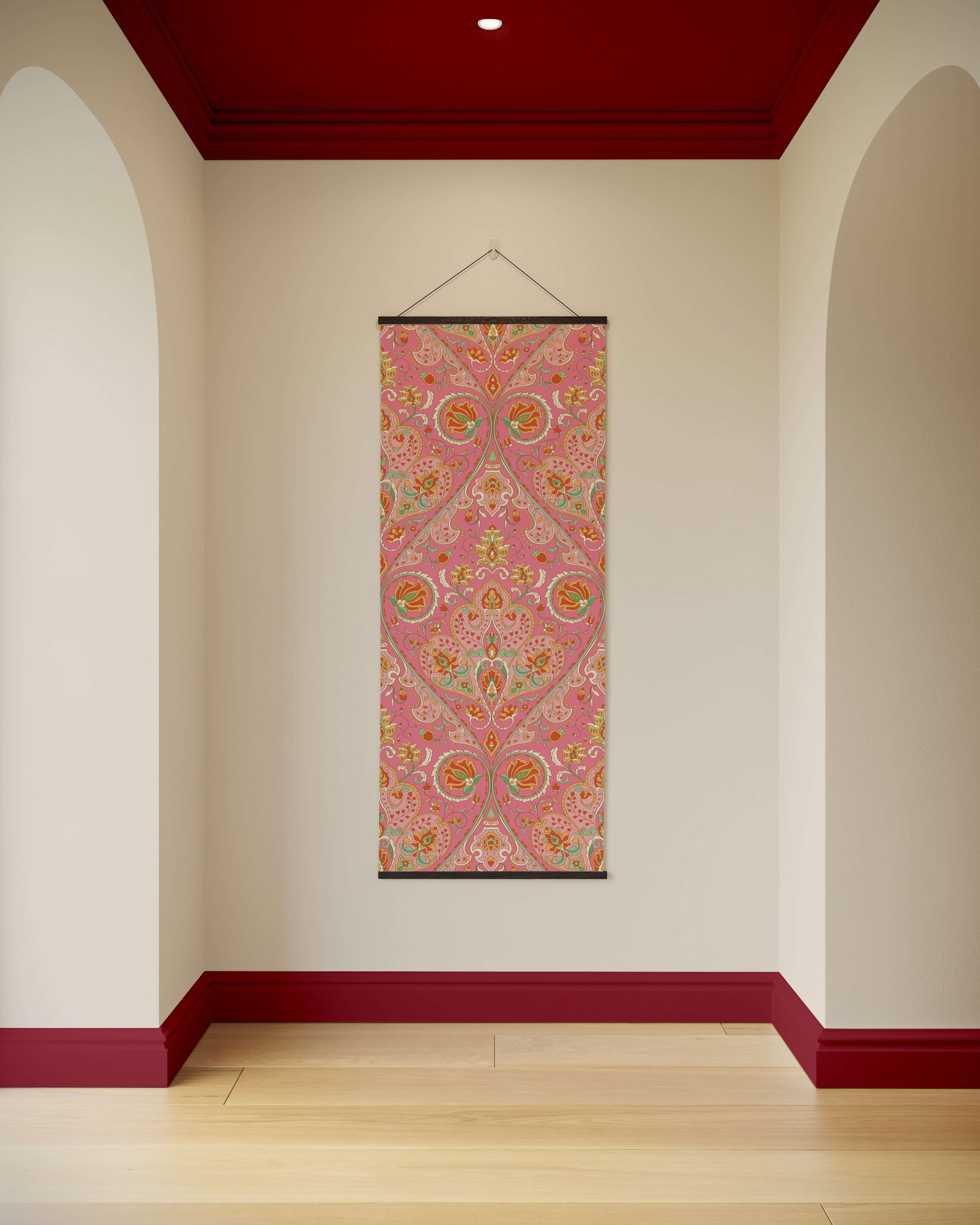 Decorative wall hanging with a pink and multicolour pattern on a white wall.