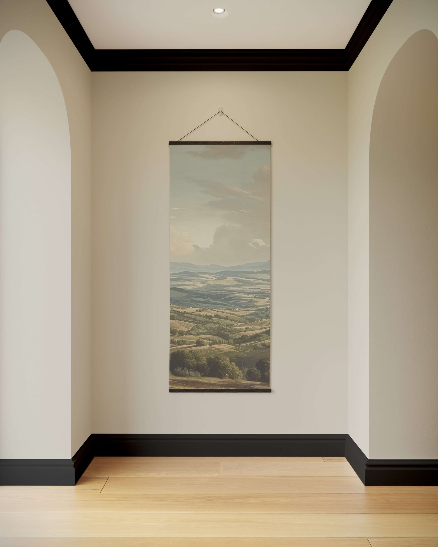 Wall art of a landscape hanging in a room with arched doorways and a wooden floor.