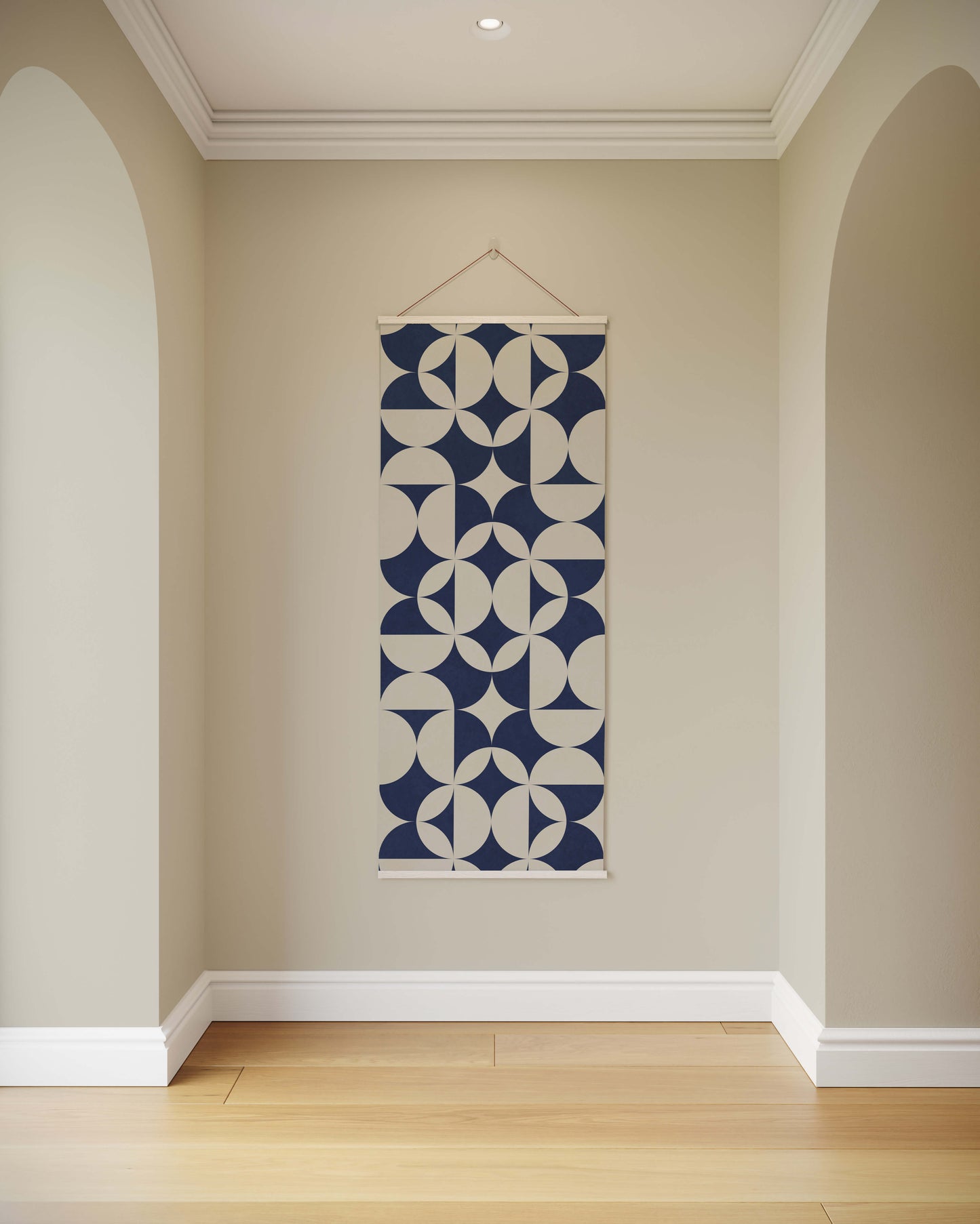 Wall tapestry with geometric pattern hanging on a beige wall.