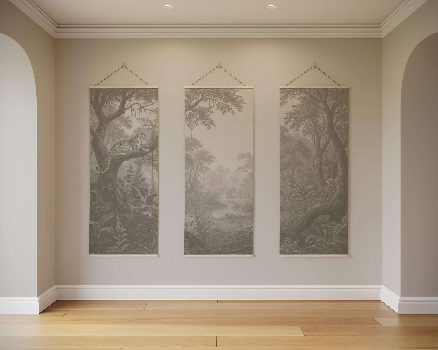Three landscape paintings hanging on a wall in a room with wooden flooring.