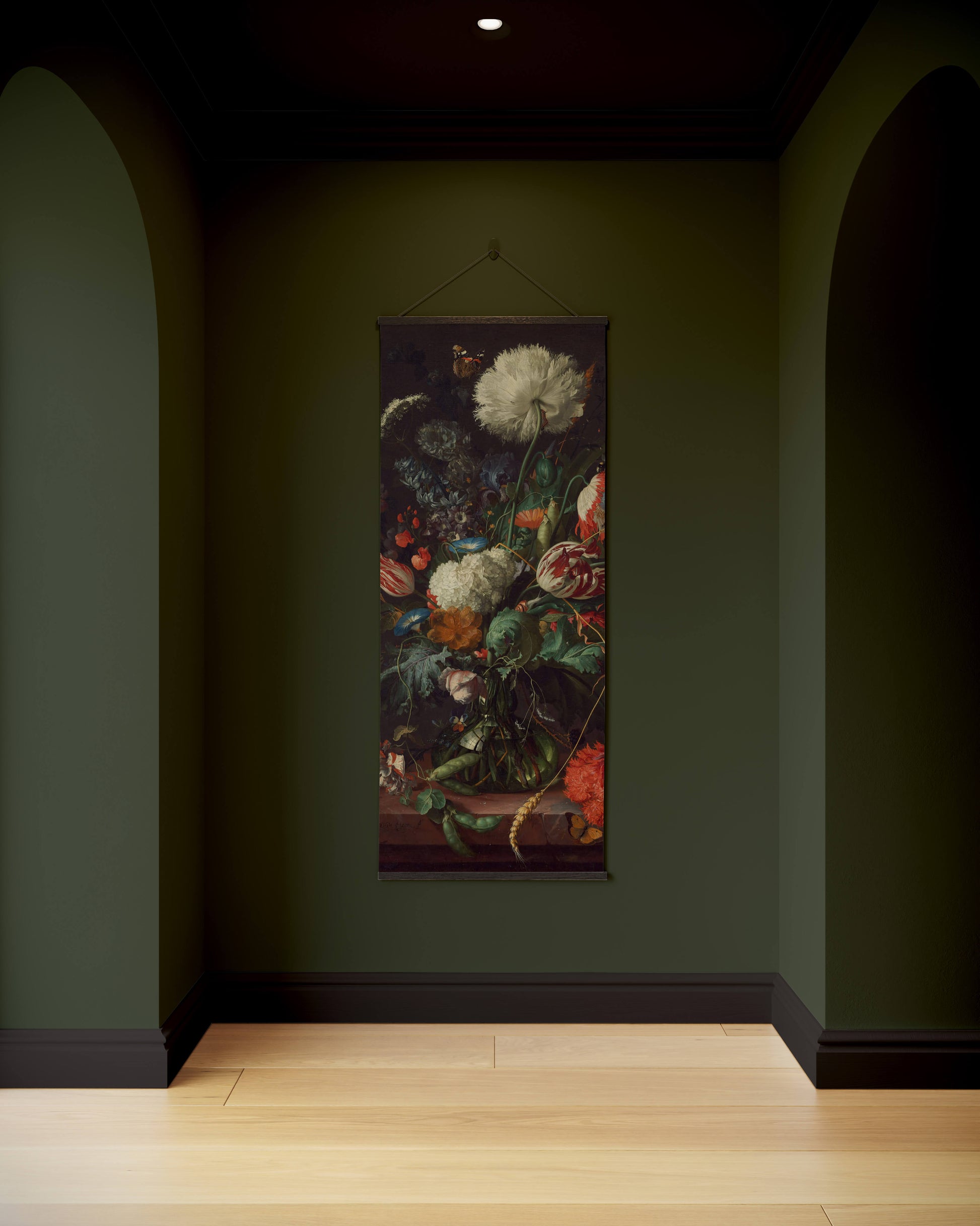 Floral tapestry hanging on a dark green wall in a dimly lit room.