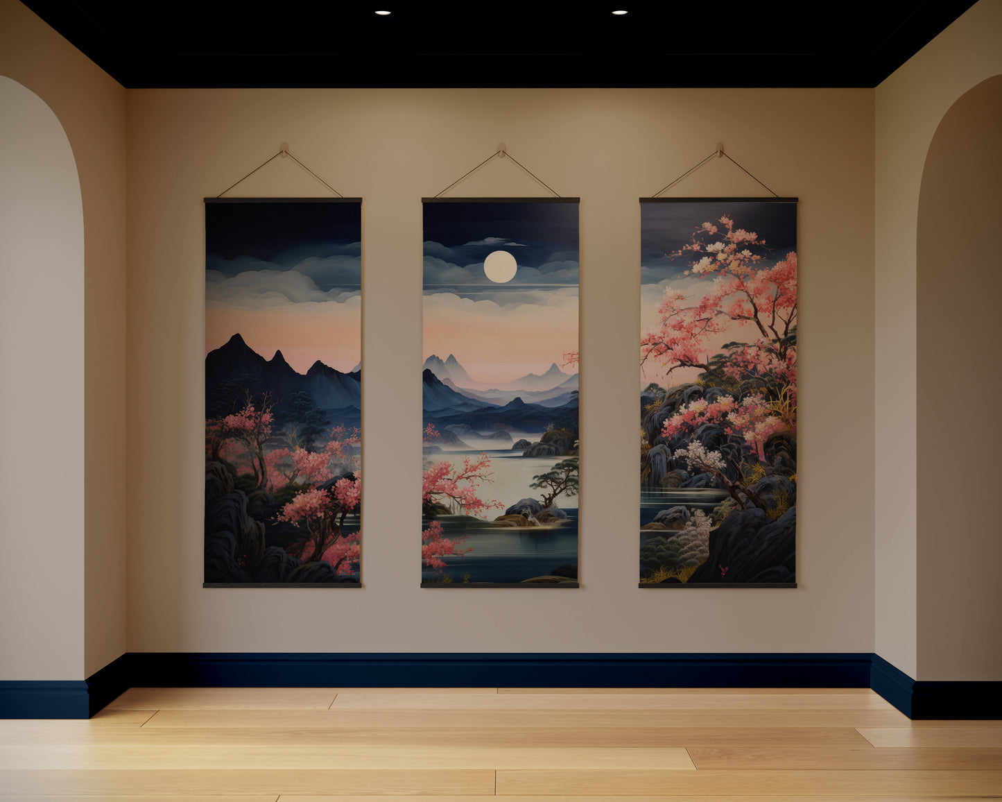 Three hanging artworks depicting a landscape with mountains, cherry blossoms, and a moon on a beige wall.