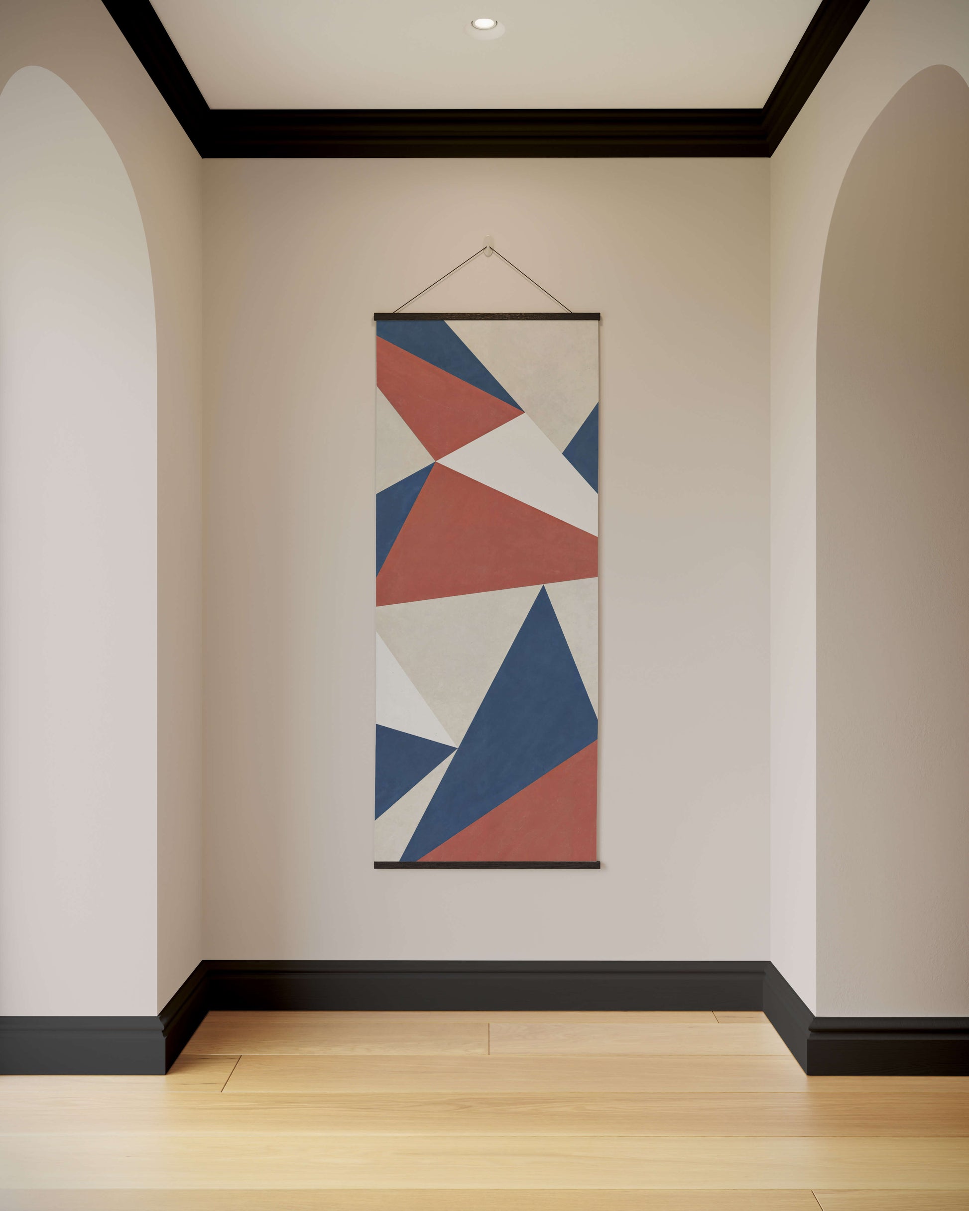Geometric patterned tapestry hanging on a wall in a room with wooden flooring.