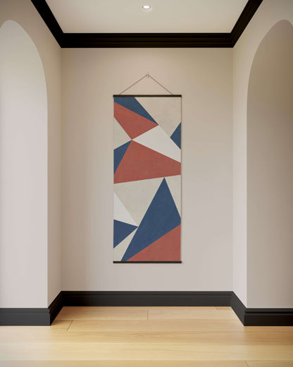 Geometric patterned tapestry hanging on a wall in a room with wooden flooring.
