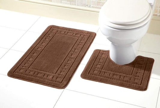Brown bath mat set in front of a white toilet on a tiled bathroom floor.