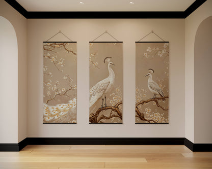 Three vertical wall hangings with bird and floral designs on a beige wall.