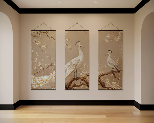 Three vertical wall hangings with bird and floral designs on a beige wall.