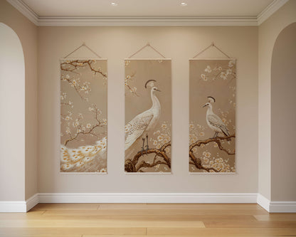 Three vertical wall hangings with bird and floral designs on a beige wall.