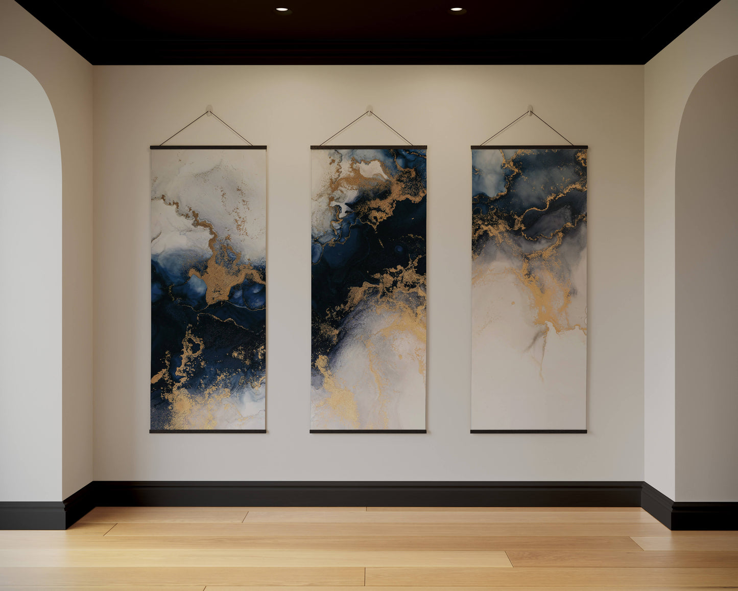 Three abstract wall hangings with blue and gold patterns on a beige wall.